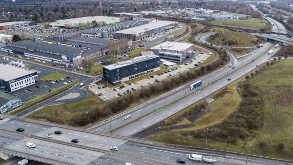 Luftaufnahme des Geländes "Lloyd Industriepark Bremen". Abgebildet werden verschiedene Gebäude und Lagerhallen. Das Gelände ist weitläufig, begrünt und mit verschiedenen Parkplätzen ausgestattet.