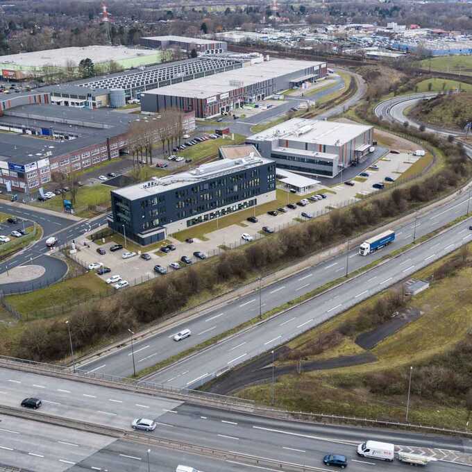 Luftaufnahme des Geländes "Lloyd Industriepark Bremen". Abgebildet werden verschiedene Gebäude und Lagerhallen. Das Gelände ist weitläufig, begrünt und mit verschiedenen Parkplätzen ausgestattet.