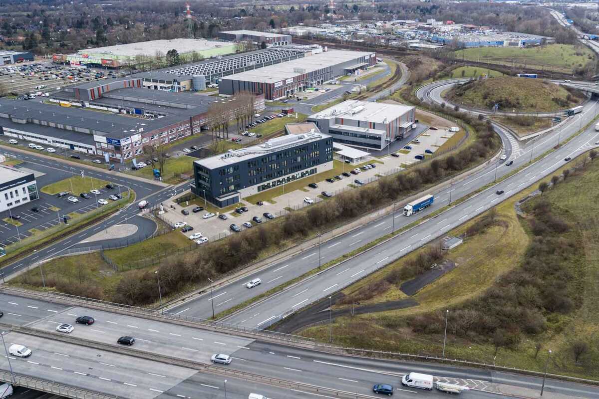 Luftaufnahme des Geländes "Lloyd Industriepark Bremen". Abgebildet werden verschiedene Gebäude und Lagerhallen. Das Gelände ist weitläufig, begrünt und mit verschiedenen Parkplätzen ausgestattet.